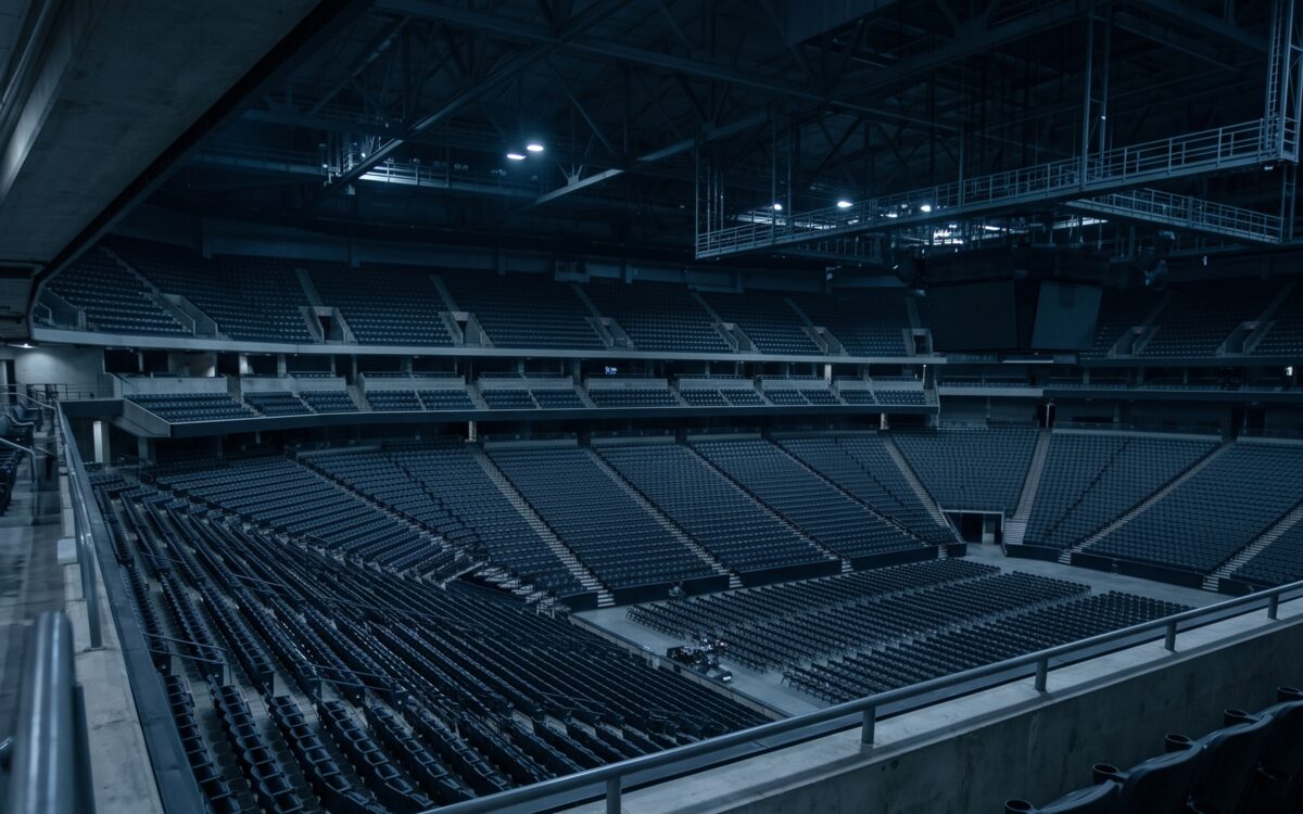 Tiers of empty seating in a darkened arena bowl